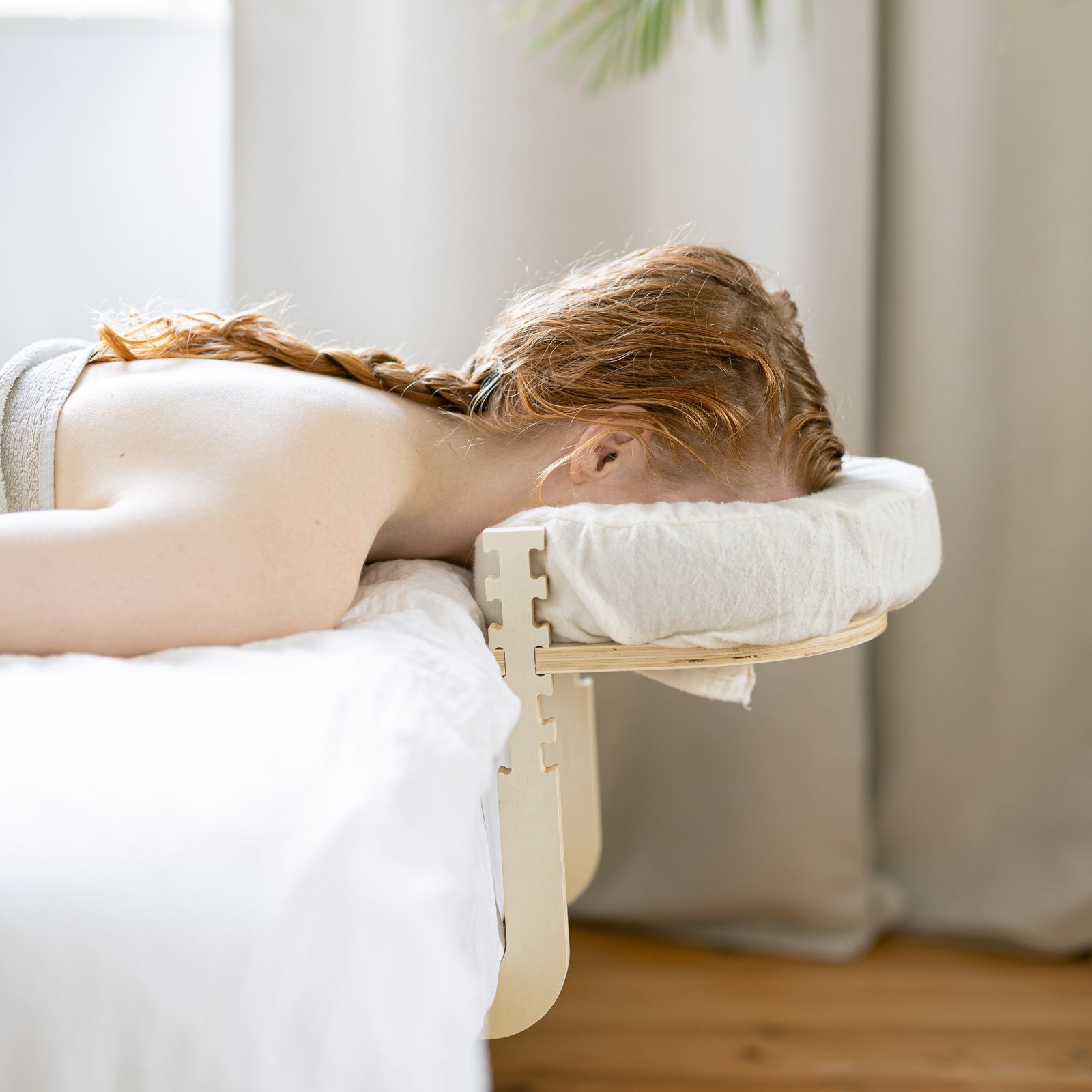 Iemand ligt ontspannen op bed met het hoofd in de Ezspa-hoofdsteun
