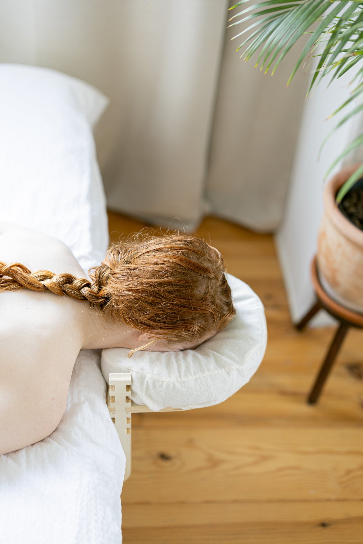 Vrouw ligt met haar gezicht in de hoofdsteun bij het raam