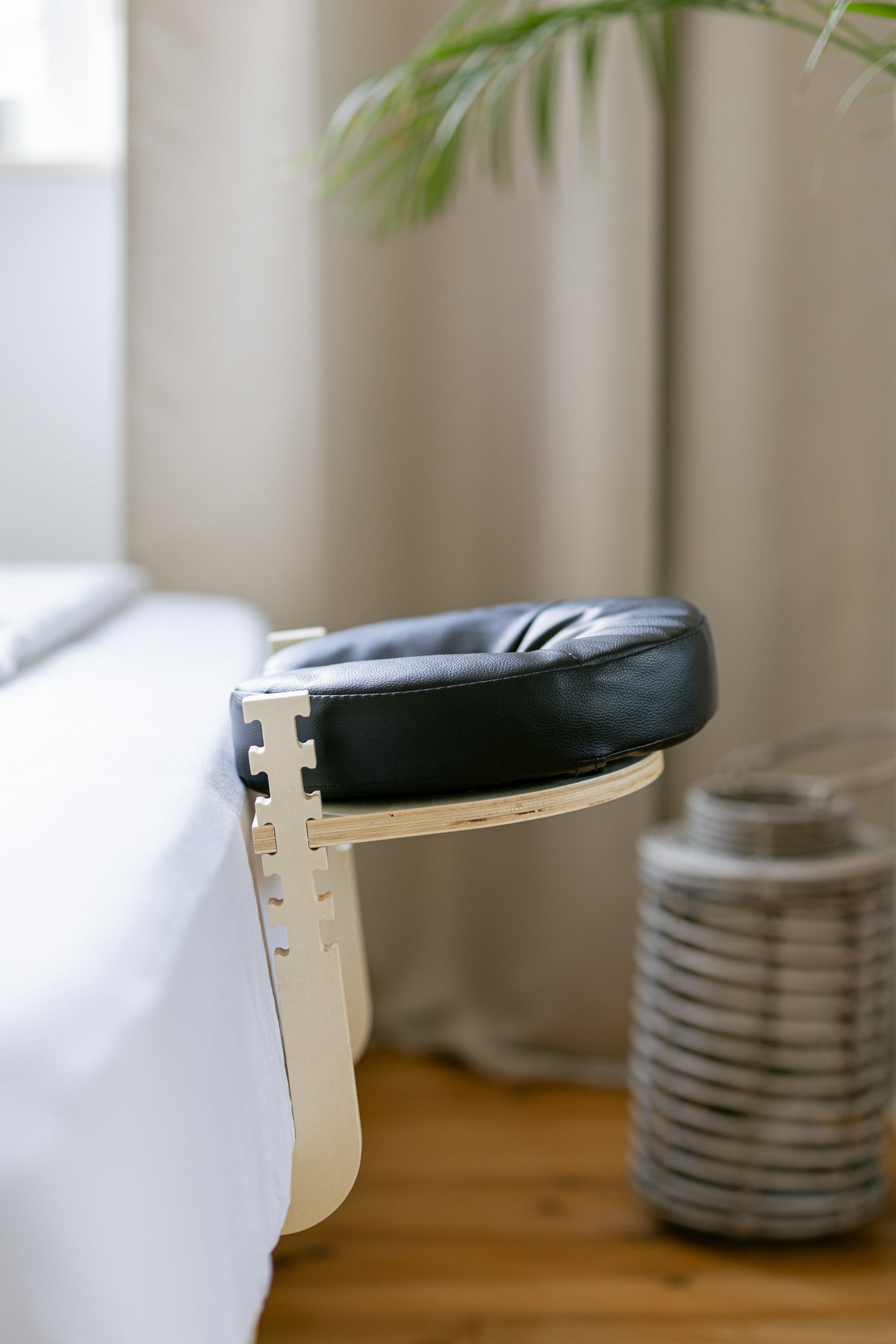 Het zwarte hoofdkussen op het houten frame aan het voeteneind van een bed
