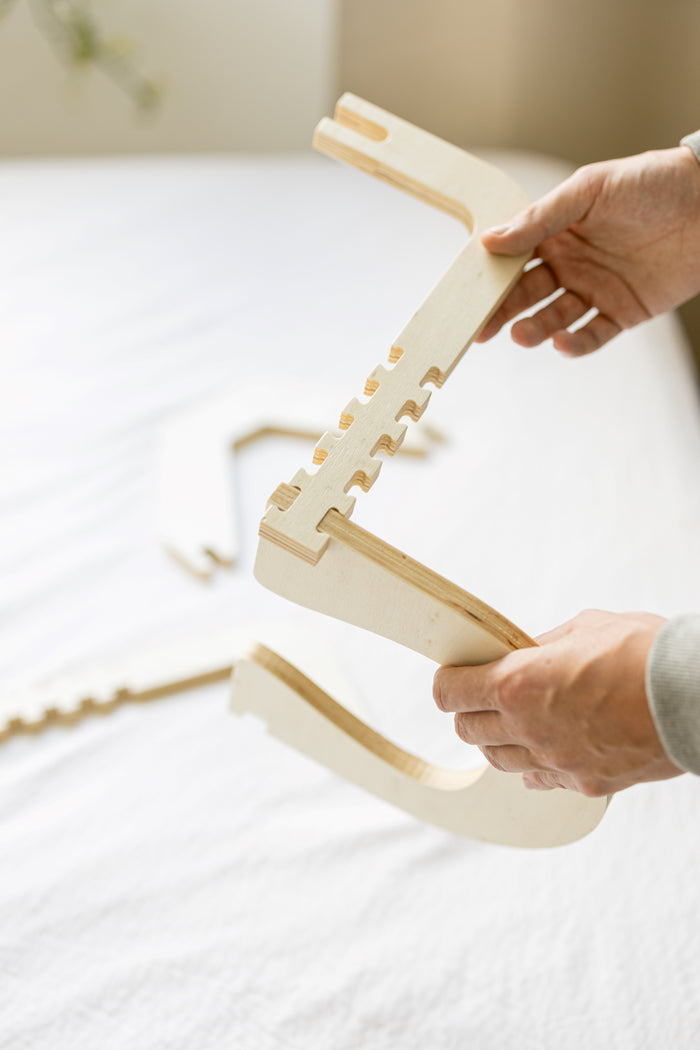 Het houten frame wordt opengeklapt boven een opgemaakt bed