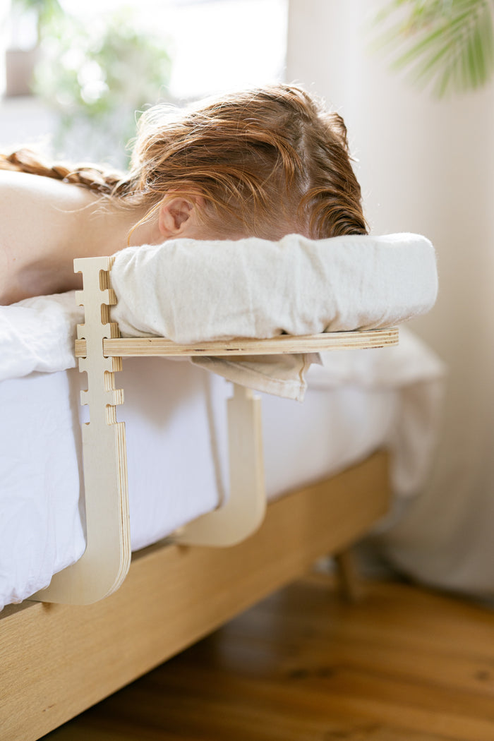 Iemand ligt met het gezicht in de hoofdsteun tijdens een massage