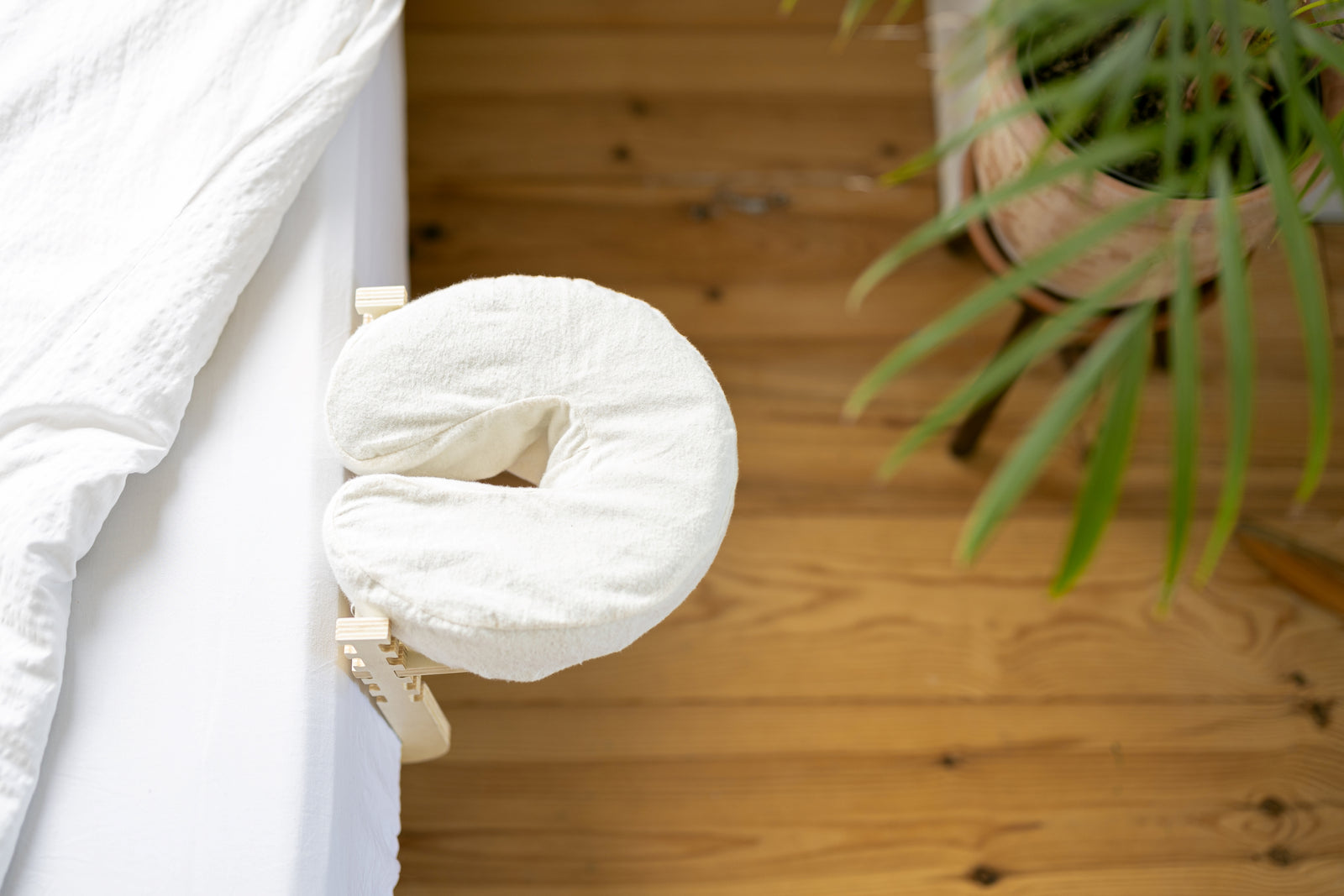 De Ezspa Bedmassage Set aan de rand van een opgemaakt bed, met een houten vloer eronder